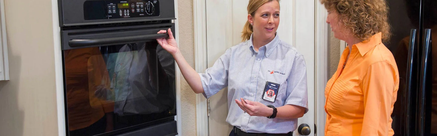 Mr. Appliance employee helping customer with oven