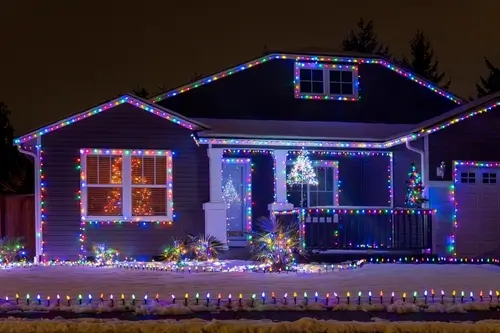 one story home with rainbow holiday lighting in winter