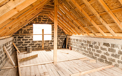 An unfinished attic with exposed wood and brick